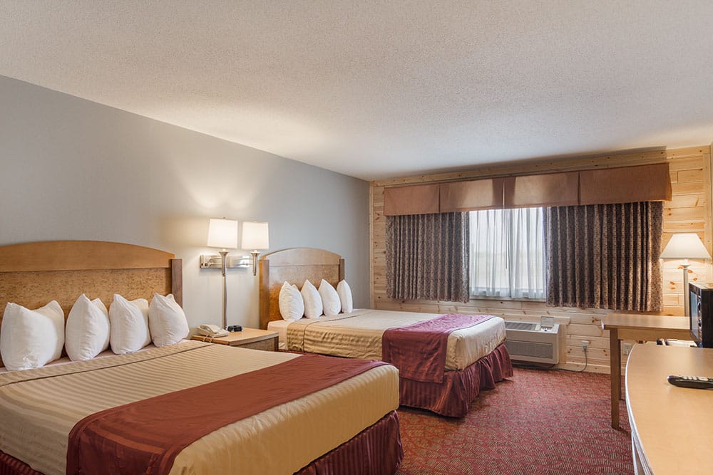 guest room with two queen beds at a boarders inn and suites